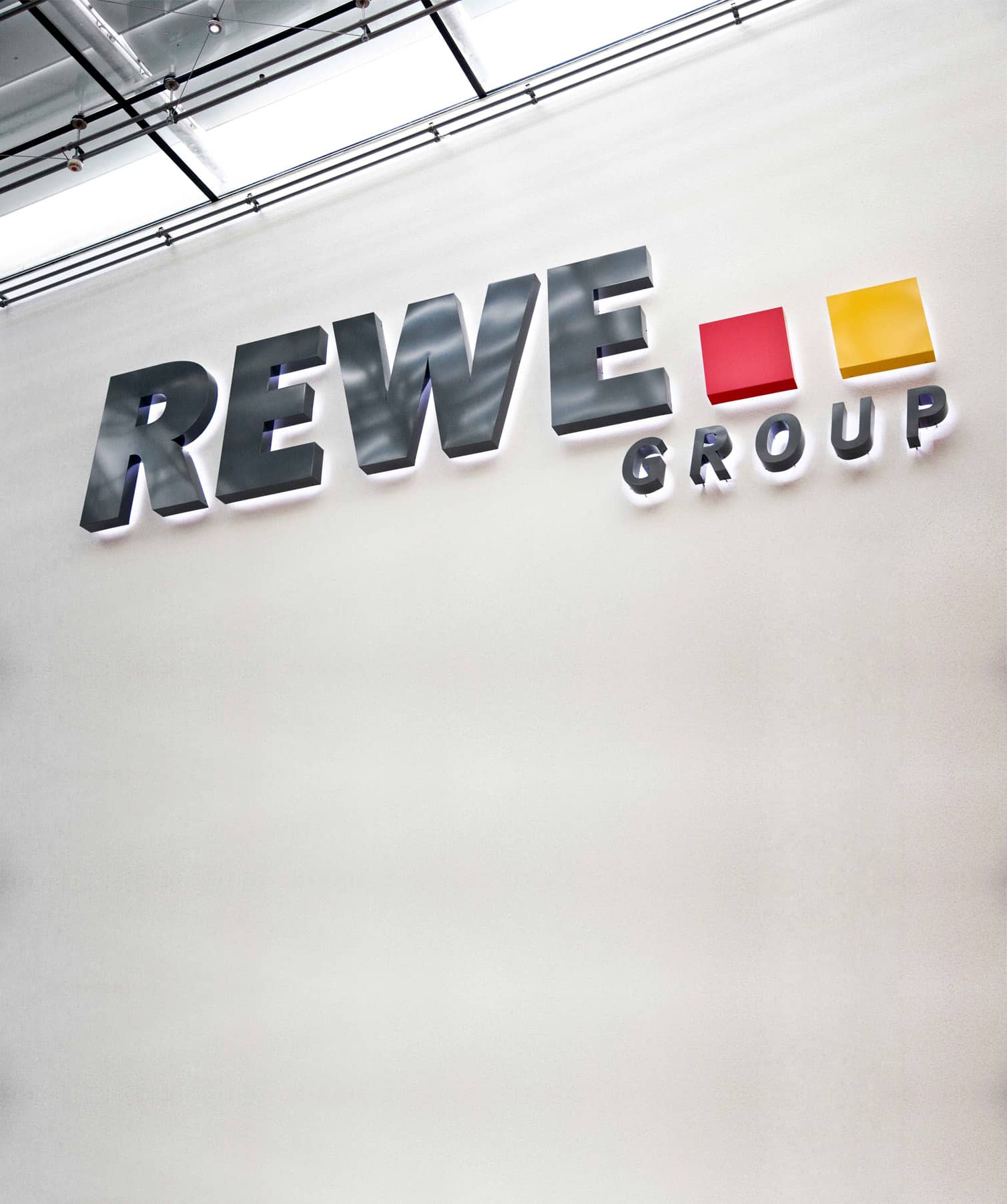Das Logo der REWE Group in 3D und beleuchtet