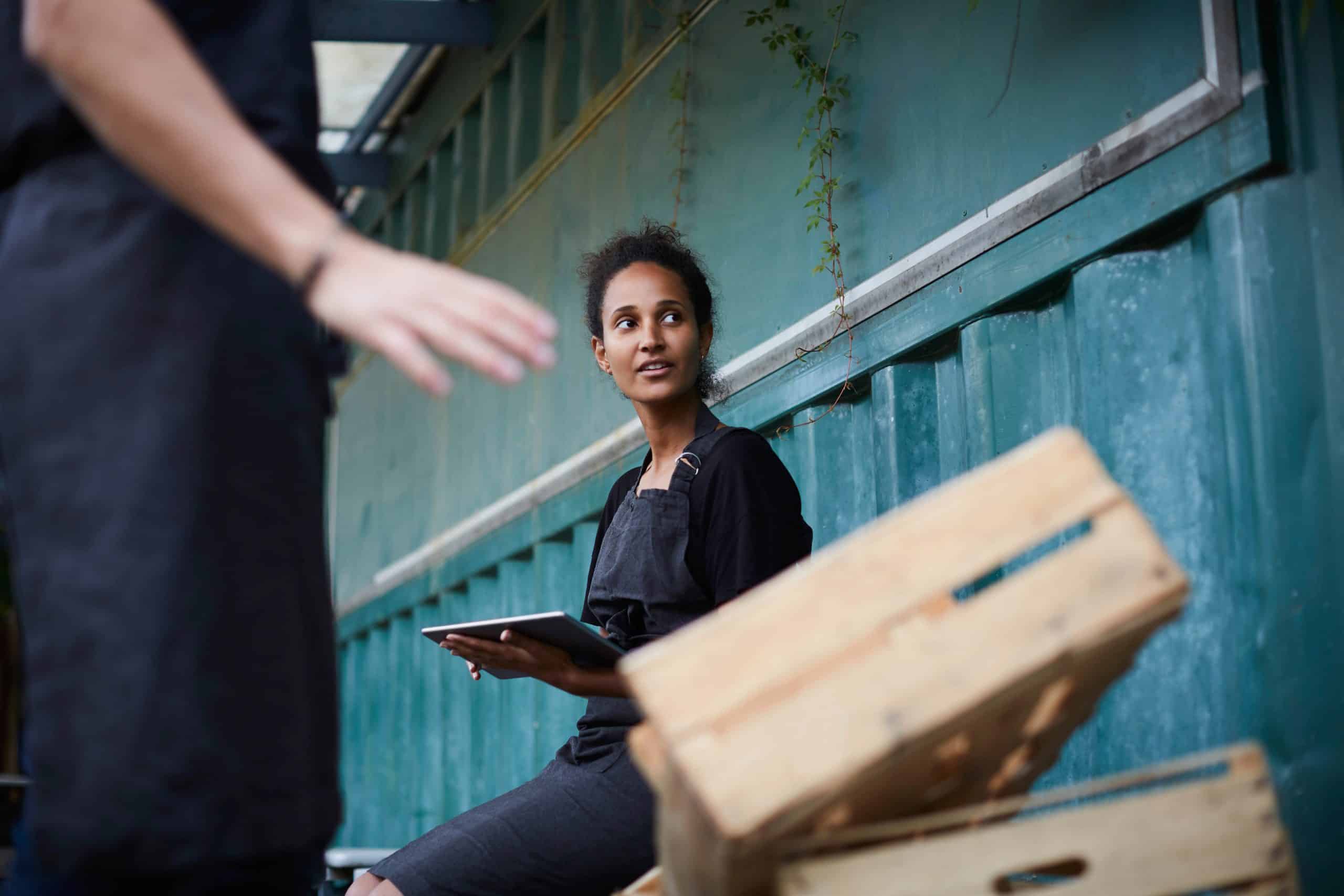 Frau hält ein Tablet in den Händen. Ein Symbolbild für die digitale Verantwortung bei der REWE Group