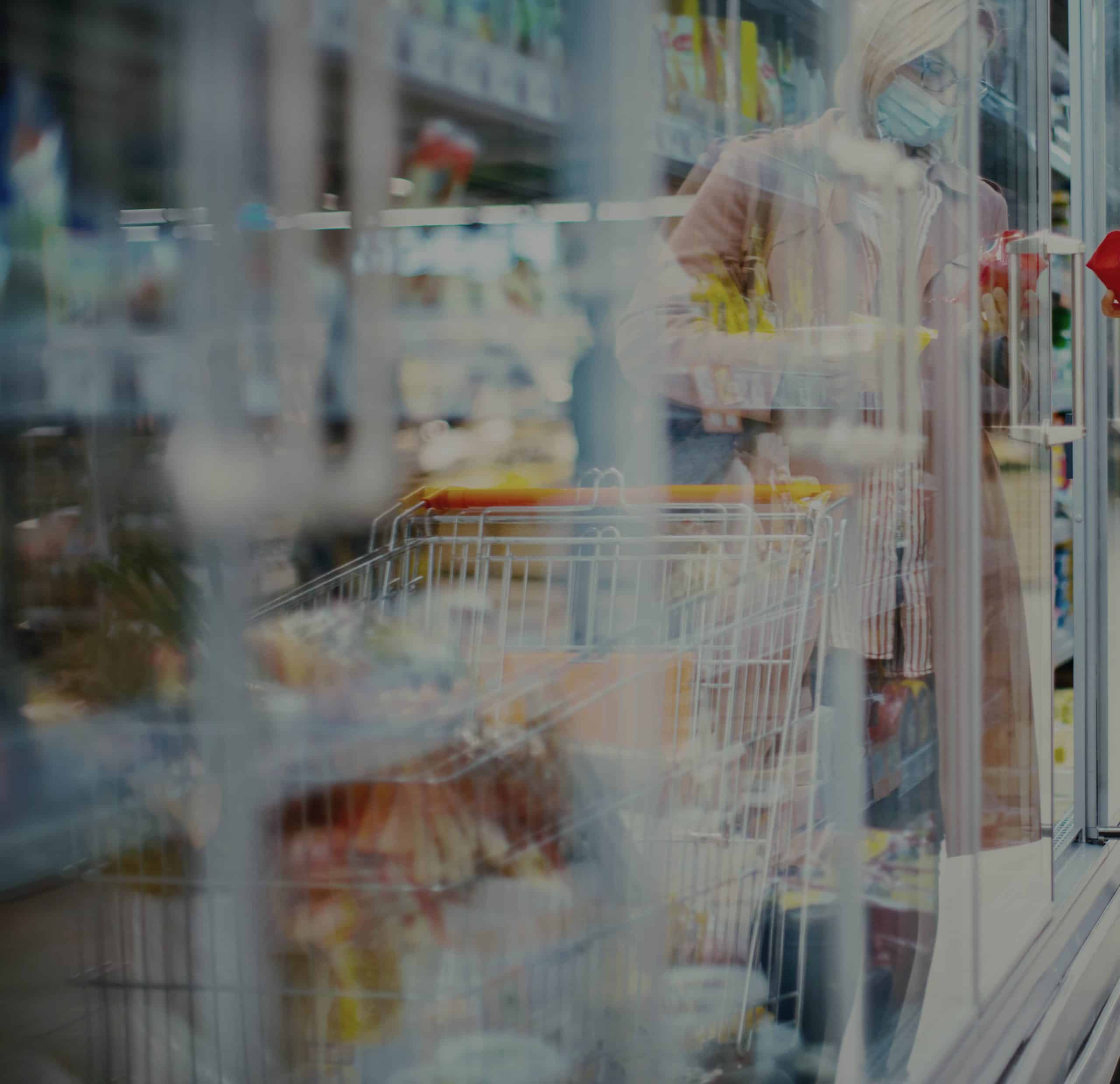Frau im Supermarkt sucht nach Käse im Kühlregal