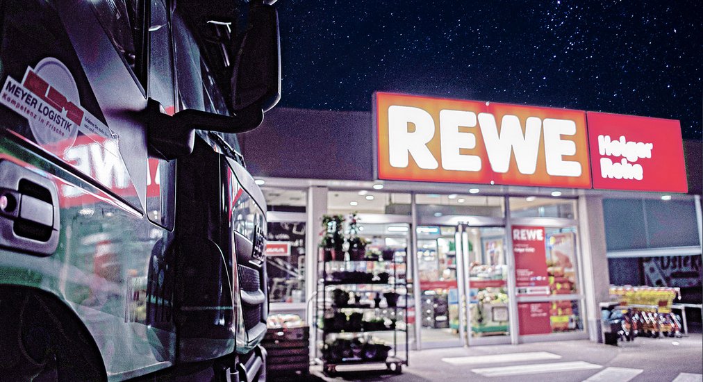 LKW parkt vor einem REWE-Markt.