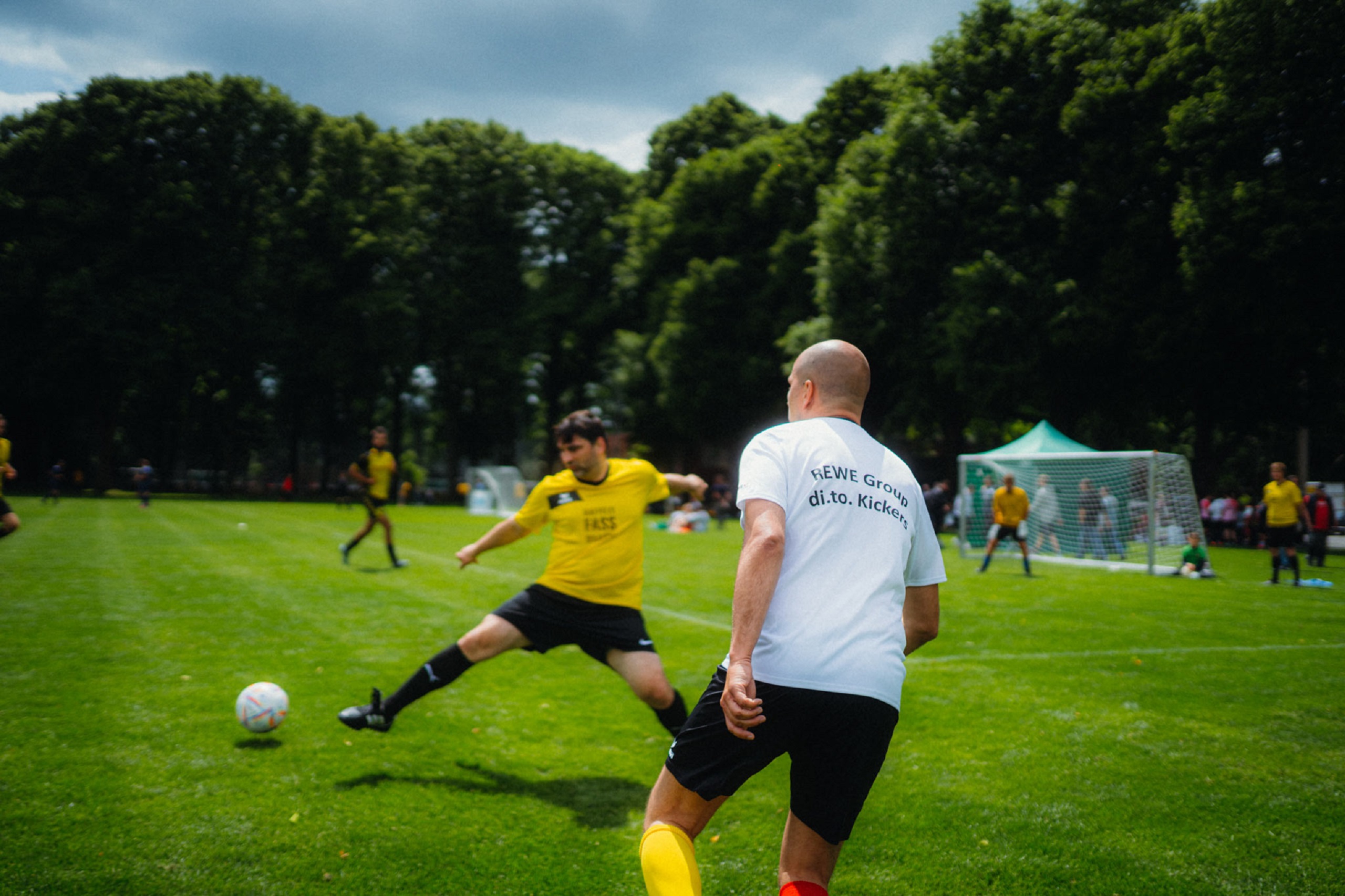 Bild eines Fußballspiels mit zwei Spielern, die vorm Tor stehen.