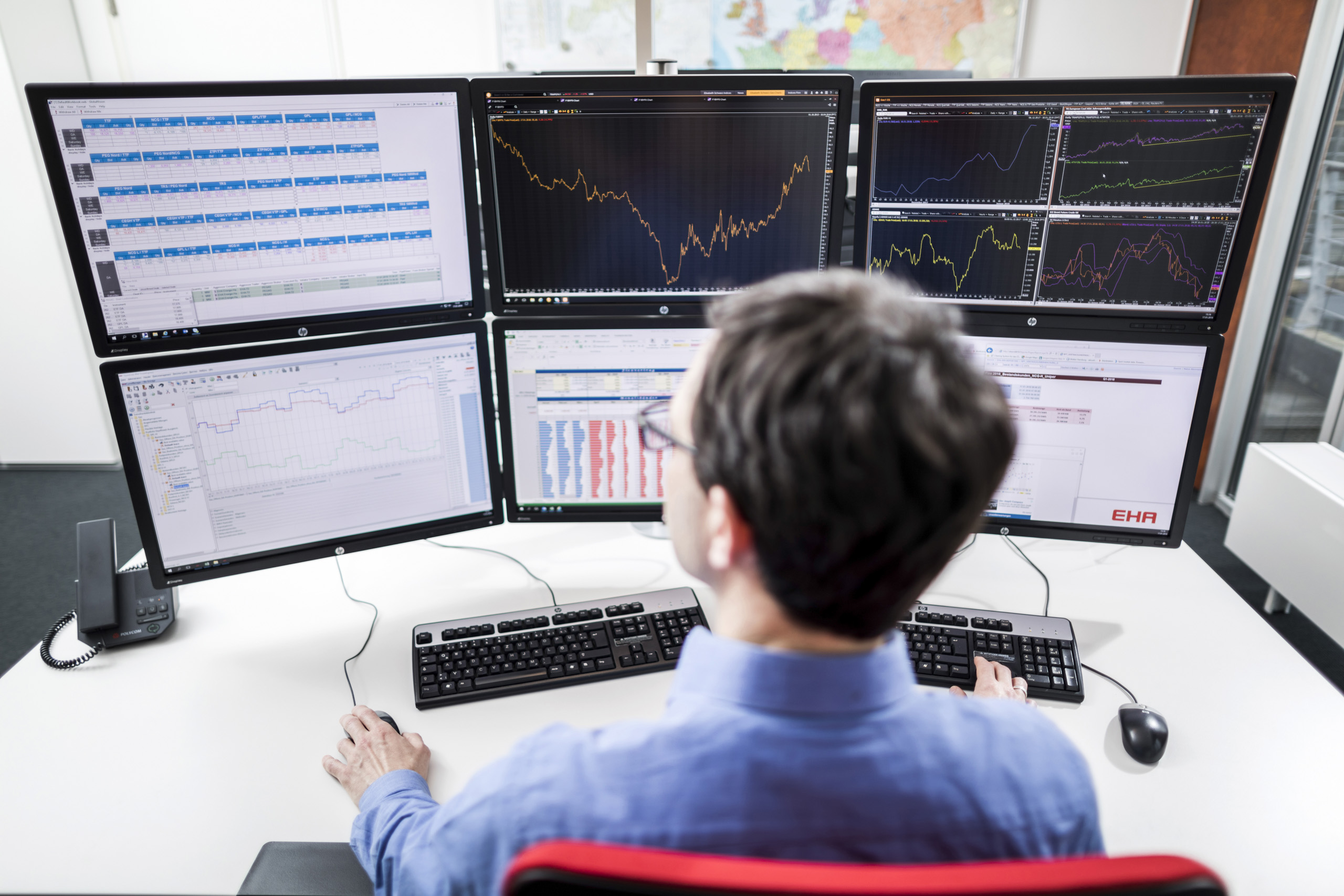 Person from behind looking at various statistics on multiple screens.