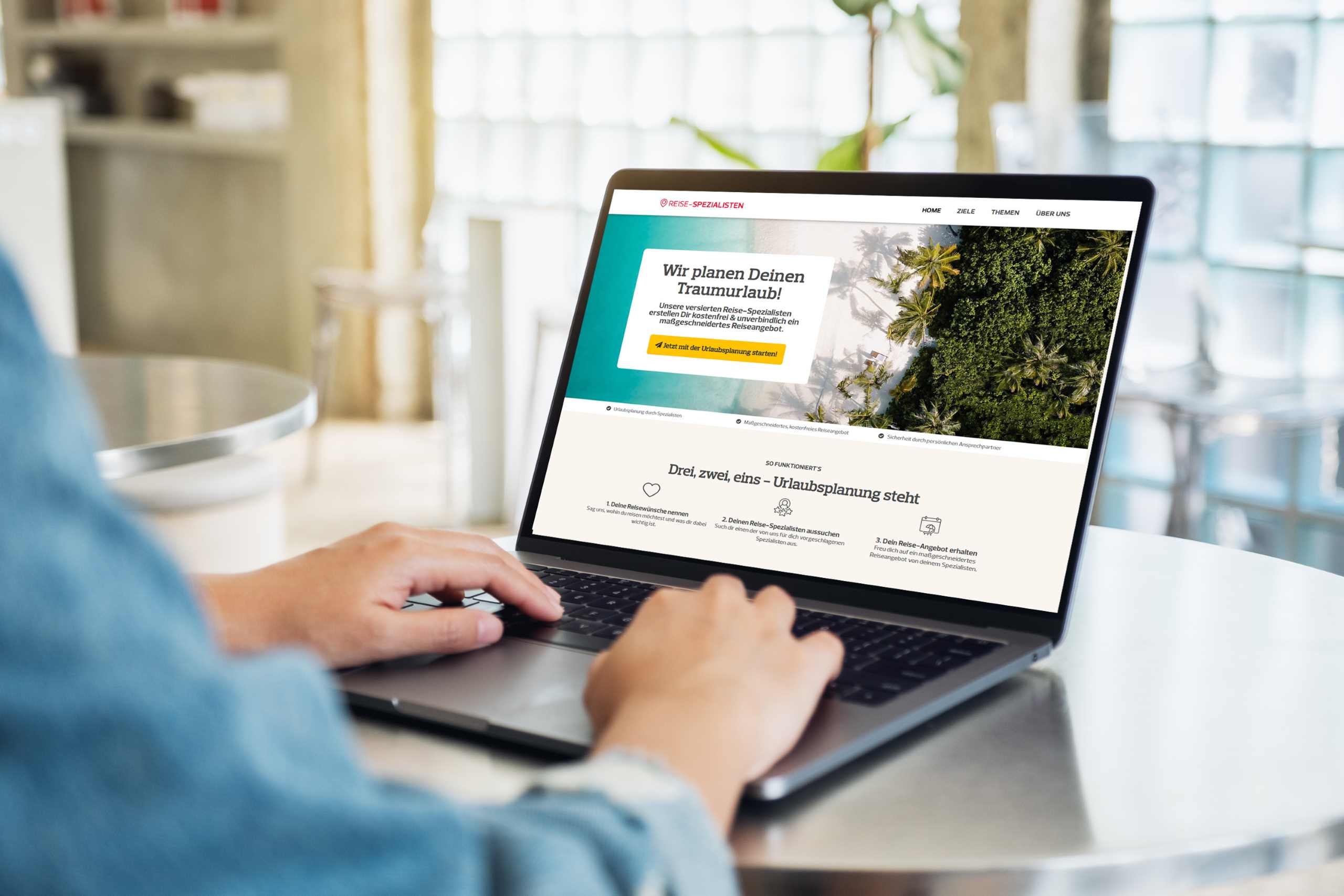 Person sitzt vor einem Laptop und schaut sich die Webseite von Dertour an.