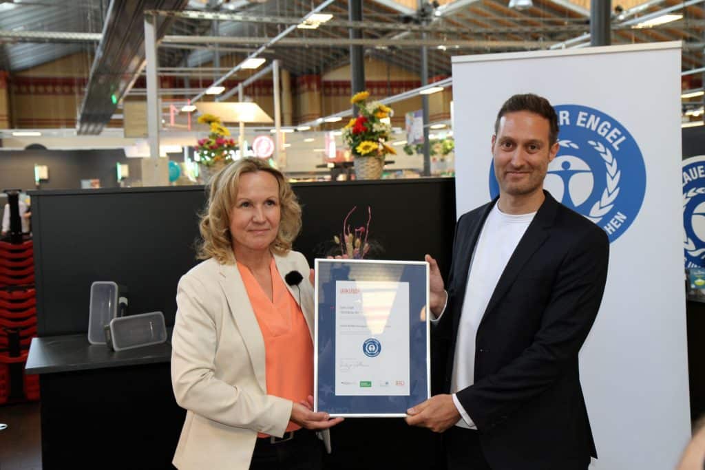 Steffi Lemke (Federal Minister for the Environment, Nature Conservation, Nuclear Safety and Consumer Protection) presenting Davide Mazzanti (CEO & Co-Founder SYKELL) a framed award.