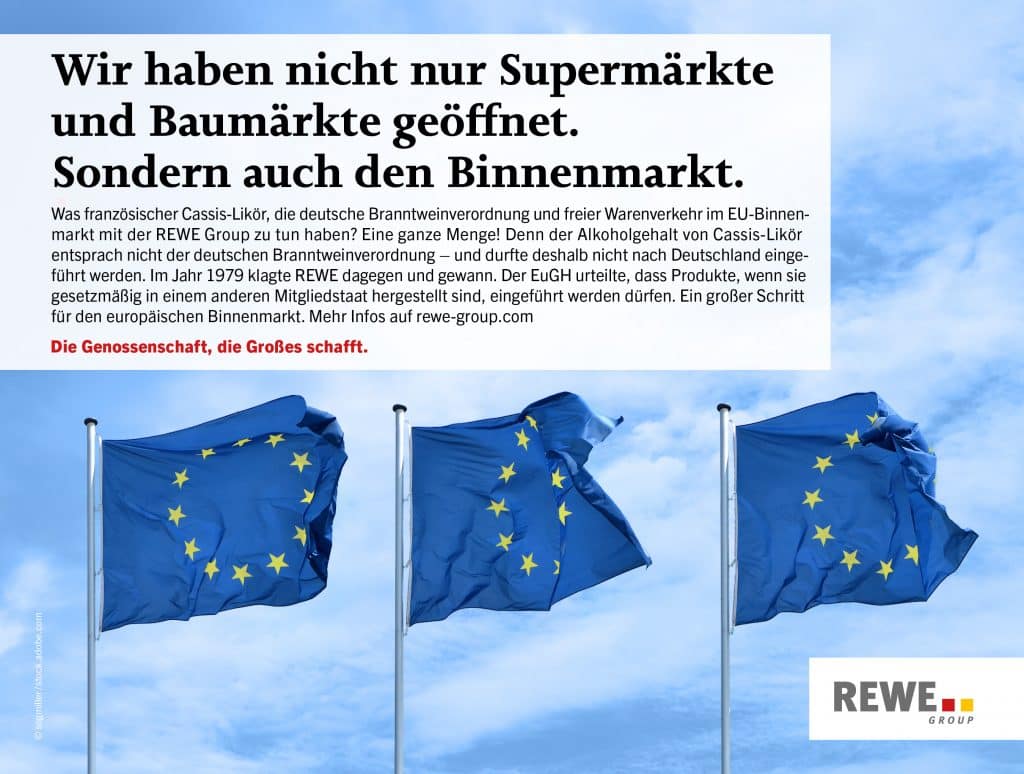 Flaggen der Europäischen Union vor blauem Himmel und dem Schriftzug 